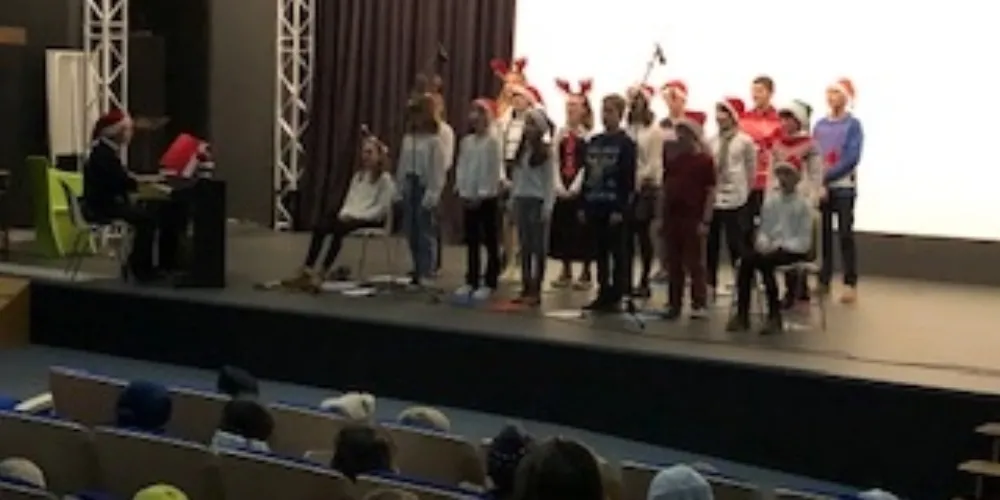 Les collégiens chantent au marché de Noel de l'école